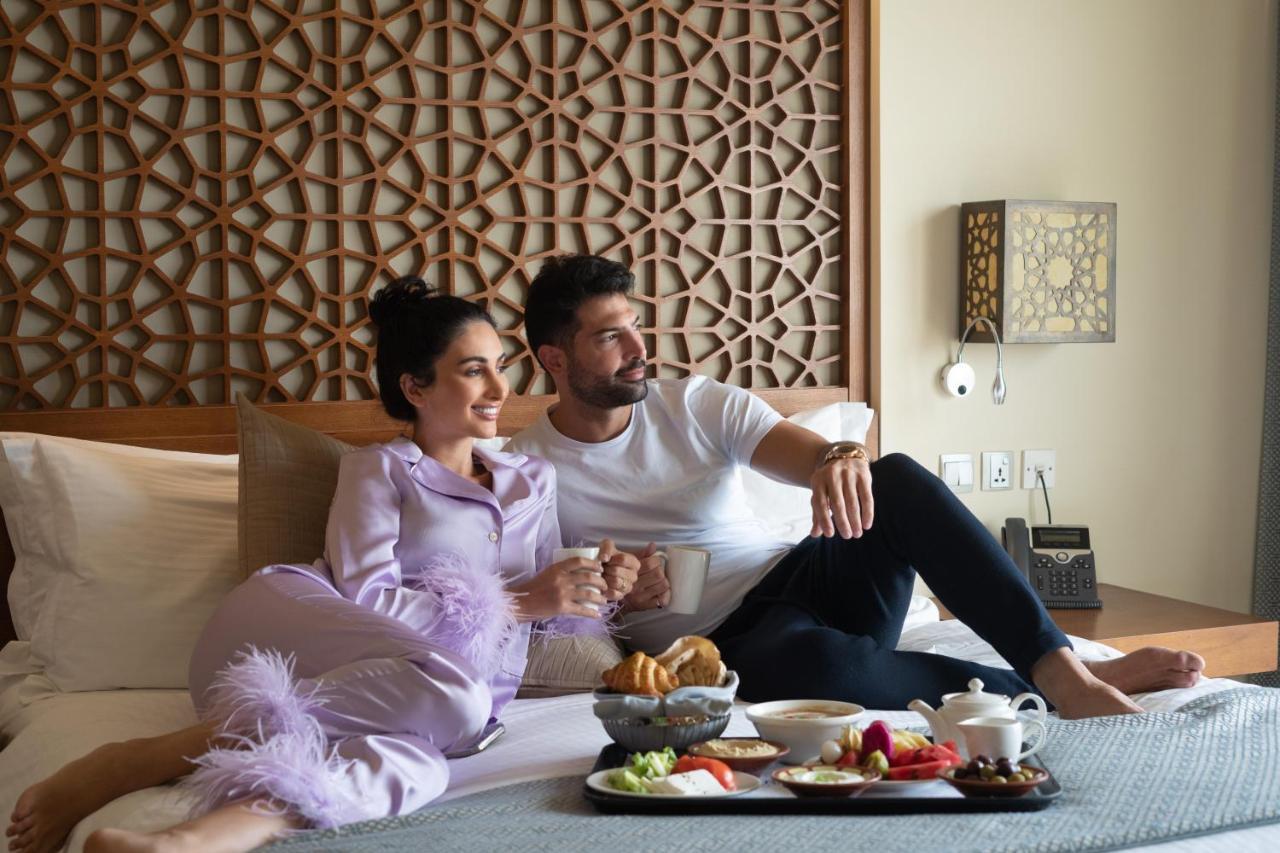 Fanar Hotel & Residences Salalah Esterno foto A couple having room service